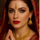 Femme européenne portant un bindi doré autocollant de 21 mm dans un décor Bollywood, gros plan sur le front avec accessoires traditionnels indiens