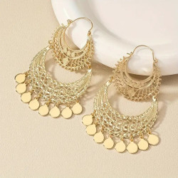 Boucles d’oreilles orientales dorées à breloques ajourées sur fond beige
