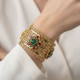 Bracelet large oriental plaqué or porté au poignet manchette arabesque pierres rouge vert