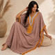 Djellaba femme pompons taupe dans une ambiance chaleureuse d'inspiration orientale.
