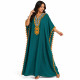 Djellaba femme pompons bleu pétrole portée assise avec élégantes finitions brodées.