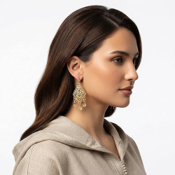 Boucles d’oreilles pendantes plaqué or style oriental portées par une femme