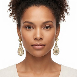 Boucles d’oreilles pendantes en plaqué or à motif oriental ajouré portées par une femme