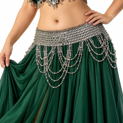 Ceinture de danse orientale élastique argent ornée de perles et de chaînettes pendantes, portée par une danseuse sur une jupe vert émeraude