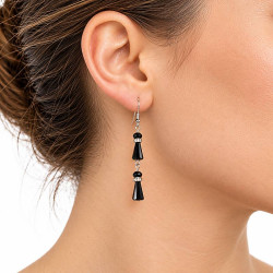 Boucles d'oreilles fantaisie à quilles noires et strass argentés portées par une femme, vue de profil